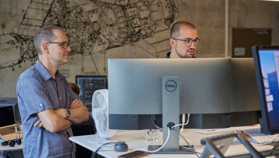 Zwei Mitarbeiter schauen auf den Bildschirm